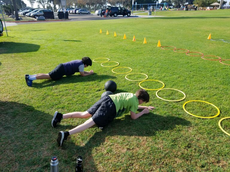 Youth athletes performing structured outdoor fitness drills at Mission Bay Park San Diego